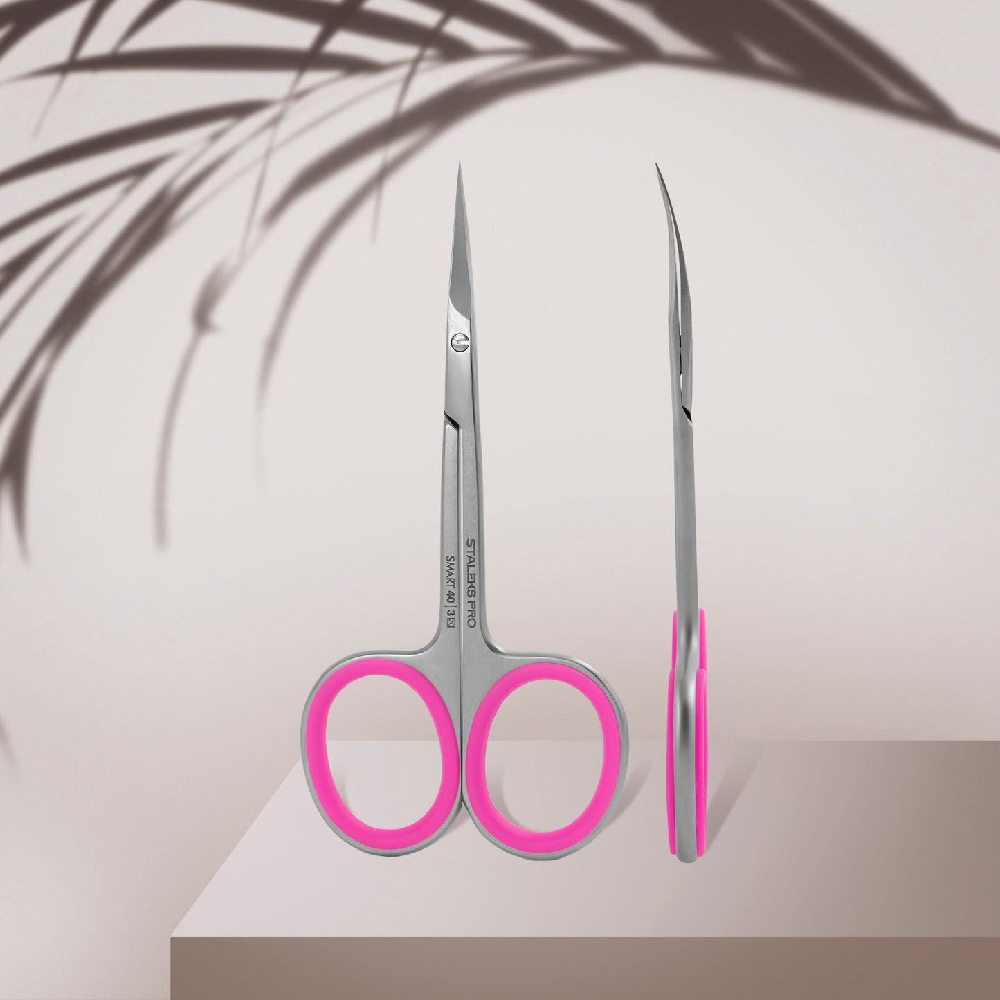 Pair of scissors with pink handles on a light background
