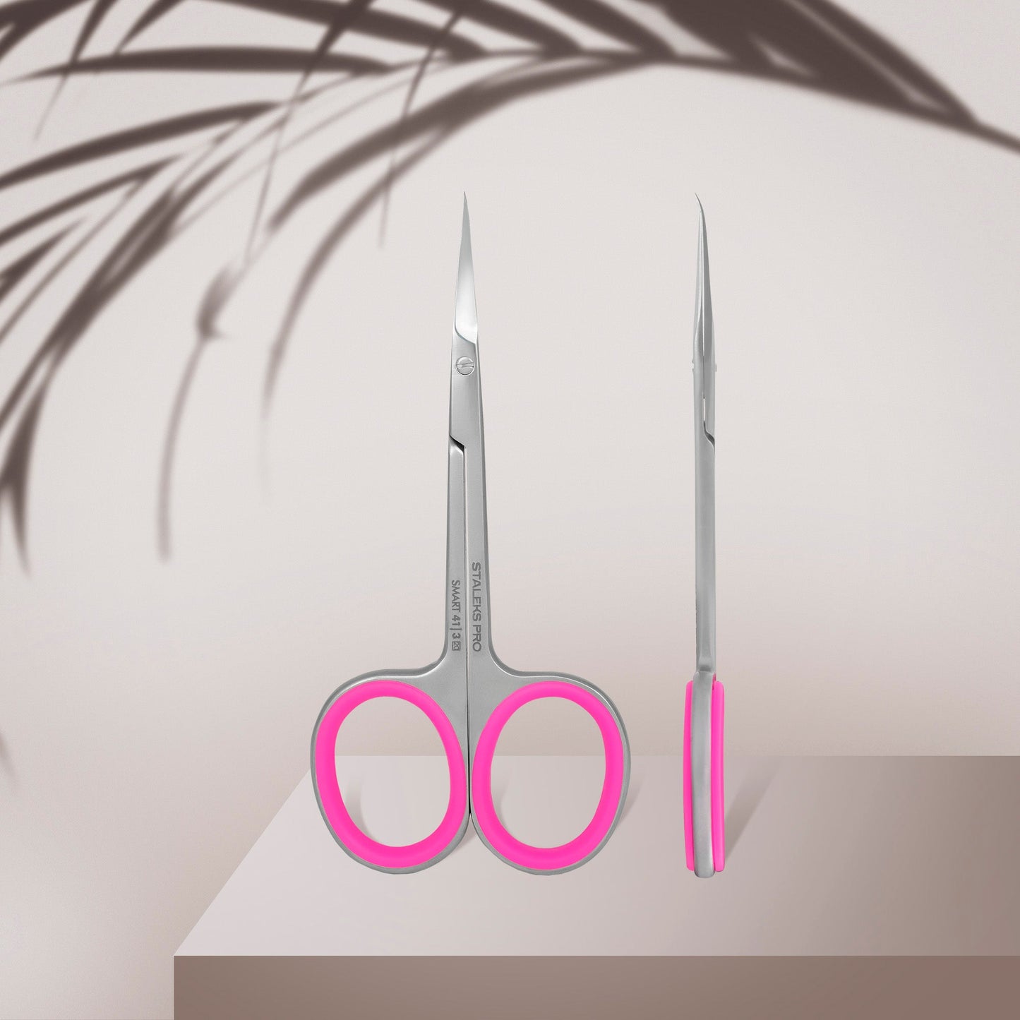 staleks Scissors with pink handles on a light background