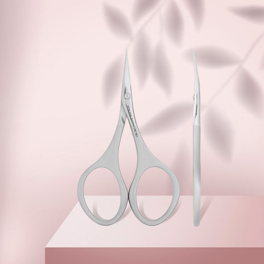 Pair of silver scissors on a pink fabric background