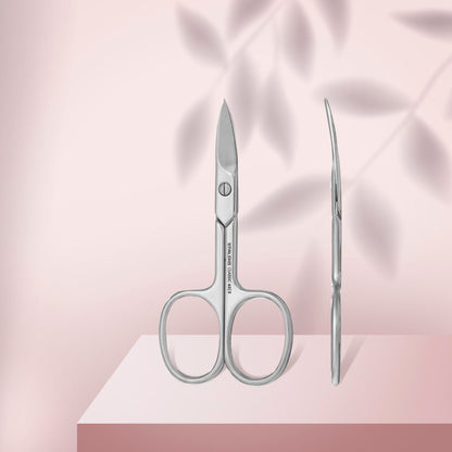 Pair of scissors and a needle on a pink fabric background
